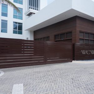 Modern building exterior with brown horizontal wood fencing and the initials “WCW&G” displayed on the structure.